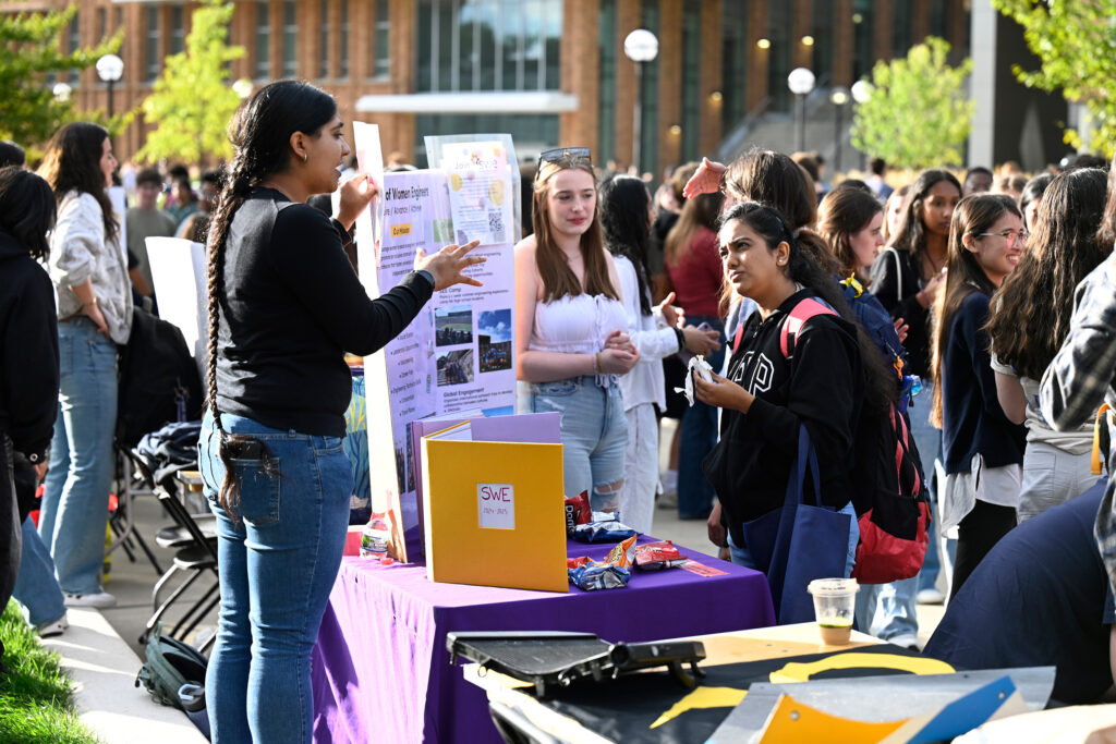 People standing around a table with posters and flyers.