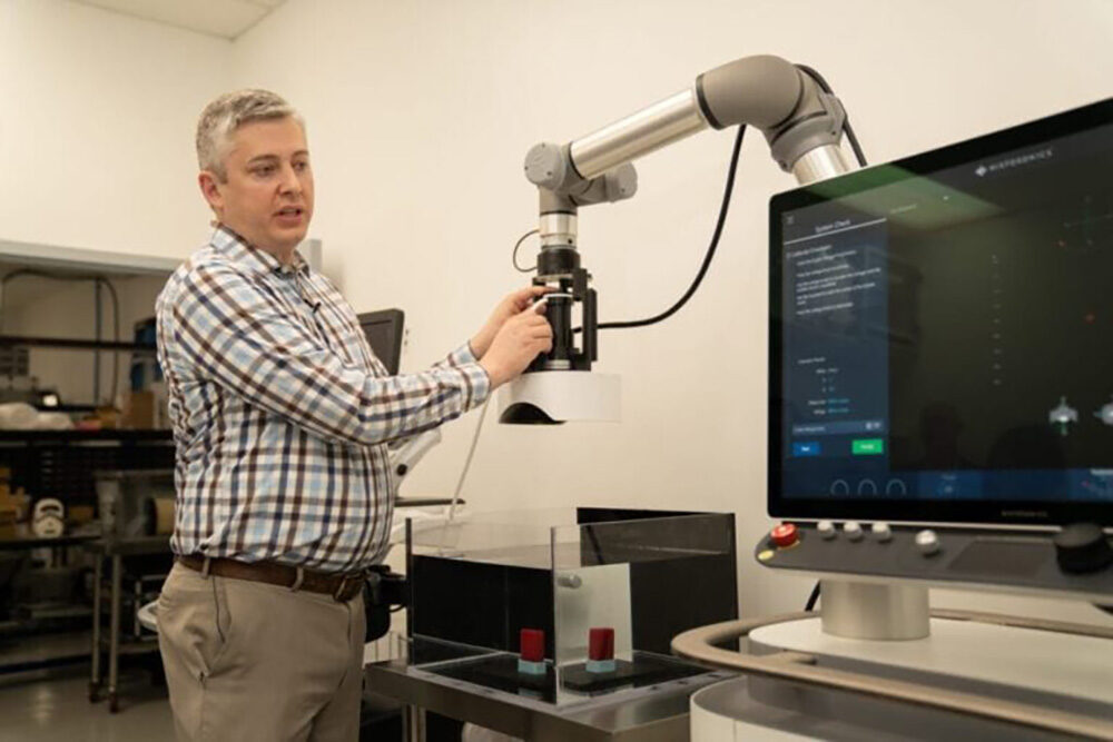A man adjusts a transducer head at a treatment plant