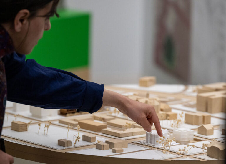 a student points out components of an architecture model.
