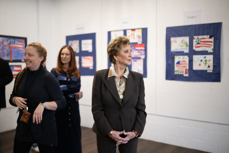 U.S. Education Secretary Linda McMahon takes in a selection of grade school students’ patriotic artworks and high schoolers’ recent output in a special installation set up at Exeter-West Greenwich Regional Junior High and High School in Rhode Island on Monday, Jan. 12, 2026. (Photo by Alexander Castro/Rhode Island Current)