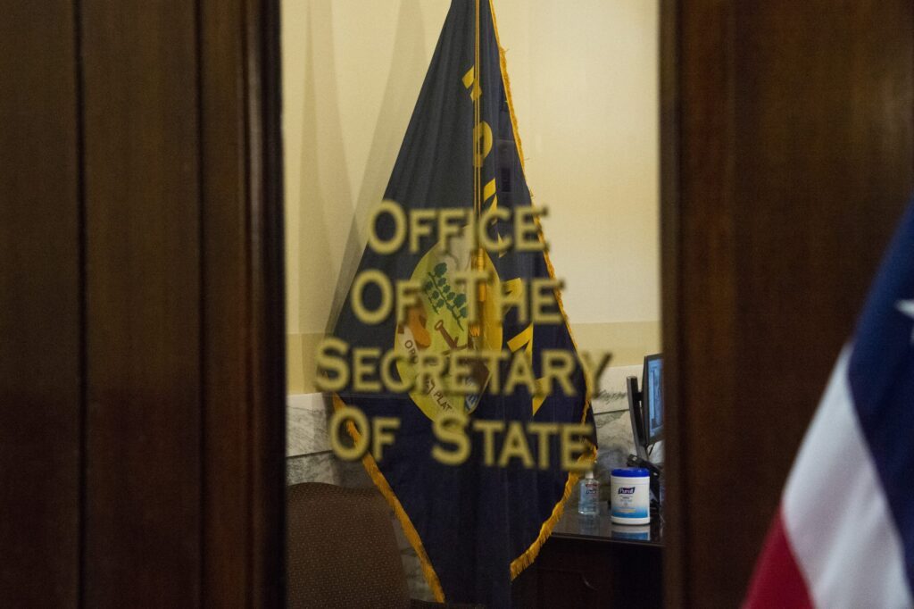 A partially obscured view through an open doorway into an office. 