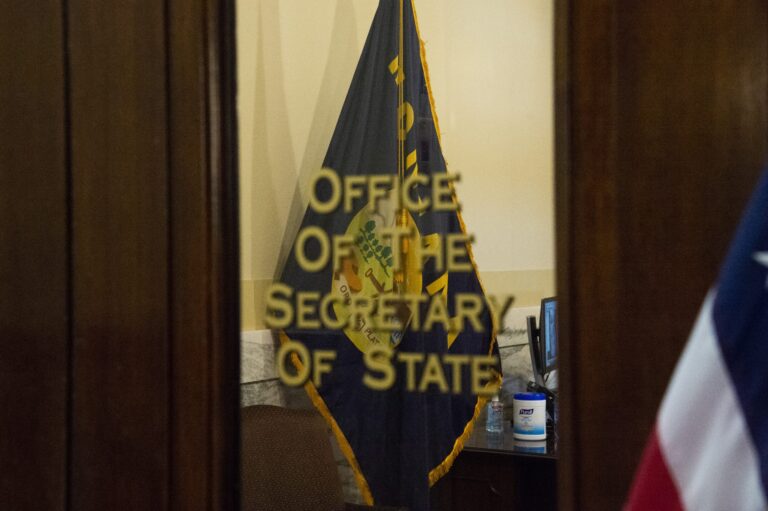 A partially obscured view through an open doorway into an office.