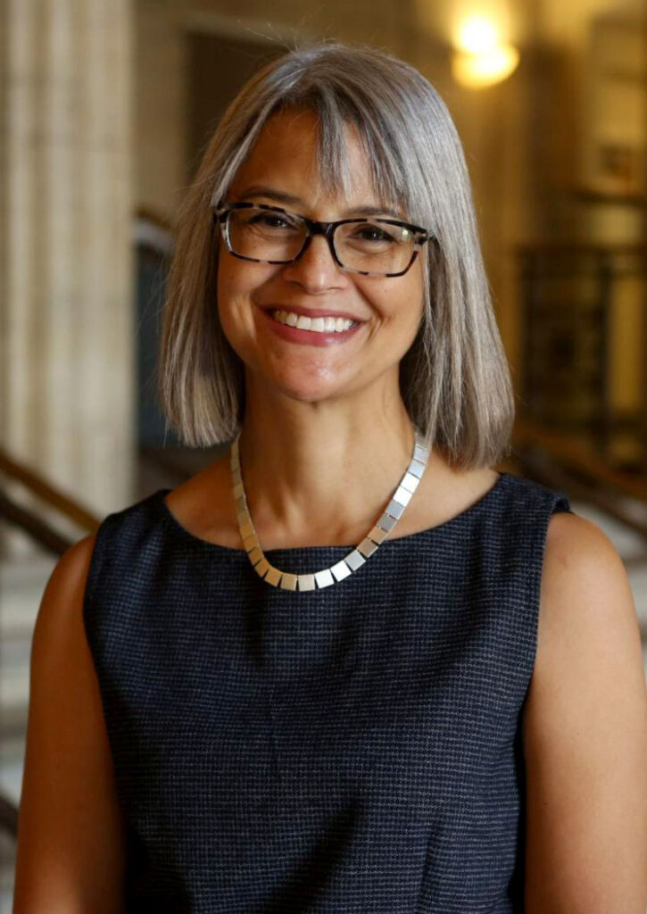 woman with glasses smiling at camera