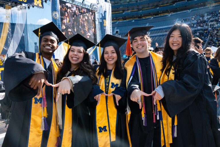 5 students posting prior to a graduation ceremony