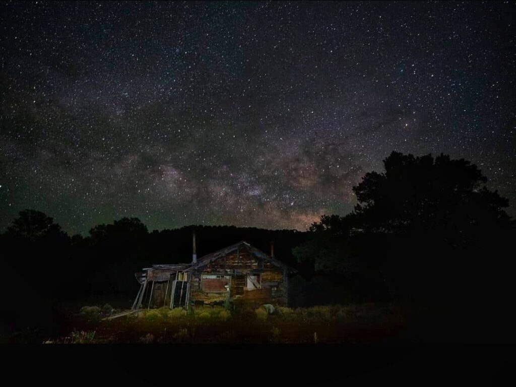Stars glow above a cabin in Catron County, New Mexico. The county, known for scenery and a dark sky for stargazers, has attracted retirees and now has one of the largest ratios of older adults to children in the country. (Photo courtesy of U.S. Forest Service by Belinda Mollard)