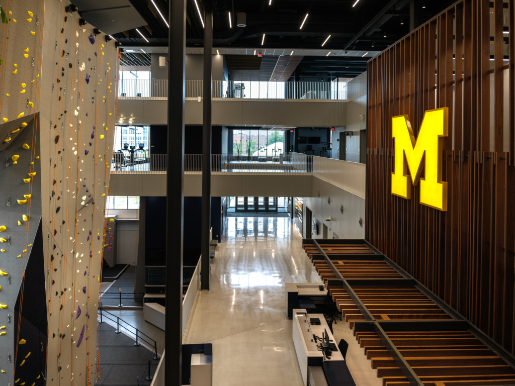 A maize lit block M hangs against a wall on the right with a climbing wall on the left