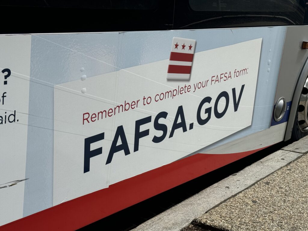 A sign reminding people to complete the Free Application for Federal Student Aid — better known as FAFSA — appears on a bus near Union Station in Washington, D.C. (Shauneen Miranda/States Newsroom)