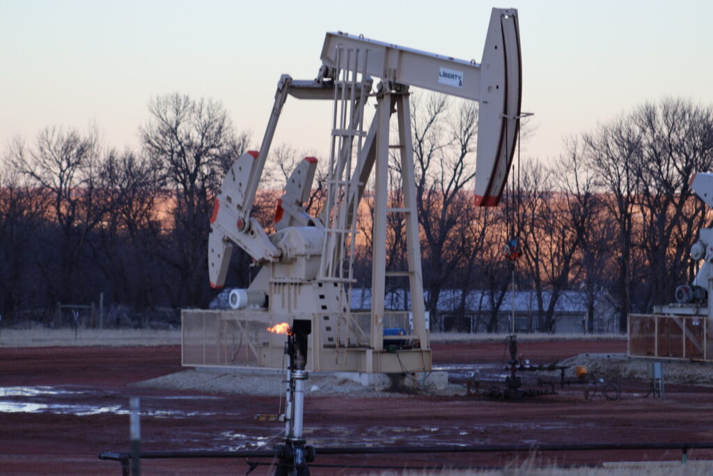 A gas flare burns in front of an oil pumpjack near Killdeer, North Dakota in 2024. North Dakota and South Dakota had large increases in personal income for the first quarter as oil prices rose, but little to no economic growth after inflation. (Photo by Jeff Beach/North Dakota Monitor)